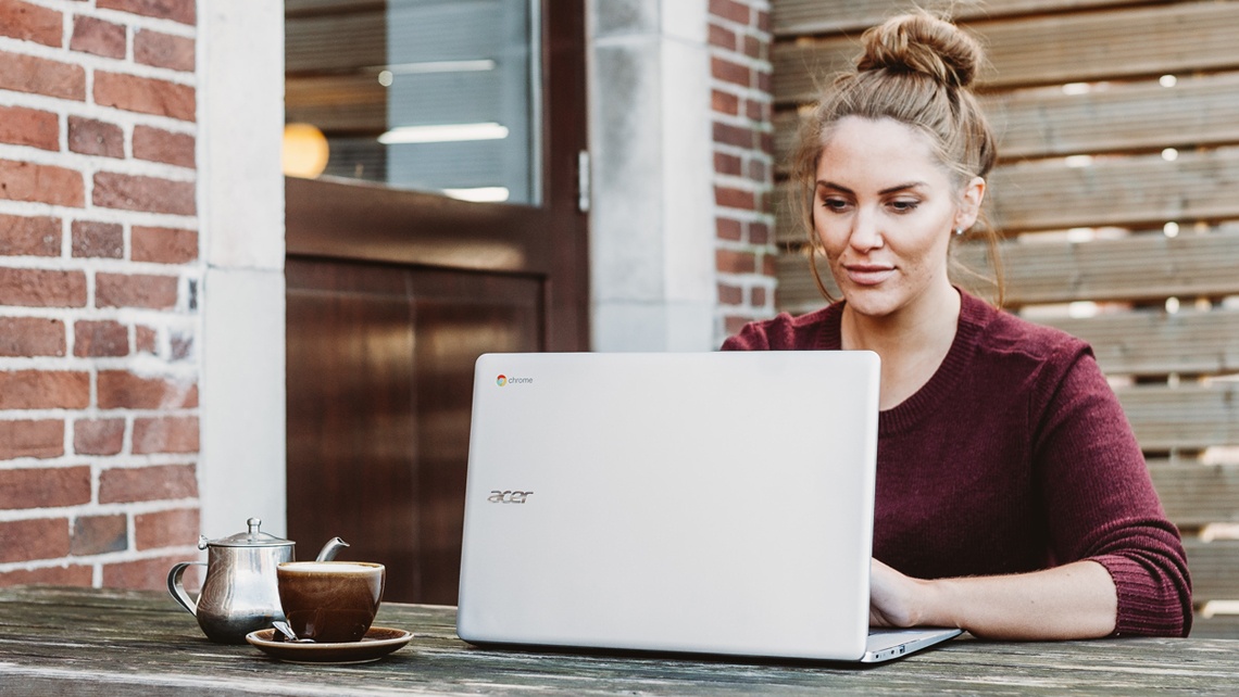 Woman working outdoors on a laptop with a cup of coffee besides her | BetterBond