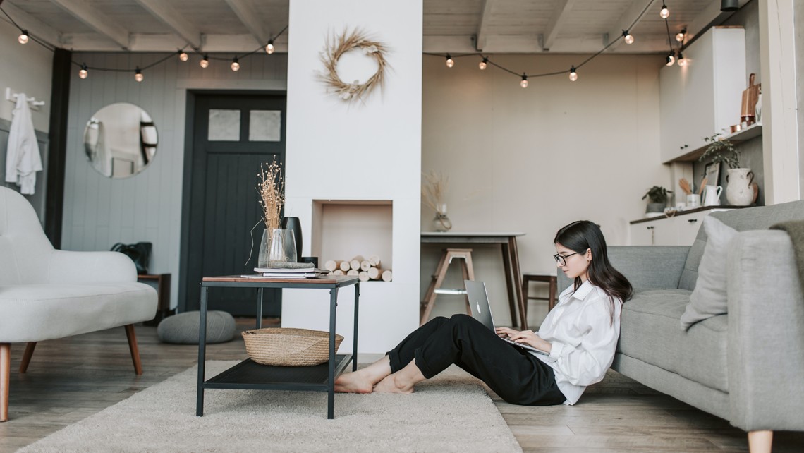 Young woman sitting on lounge floor working on laptop | BetterBond